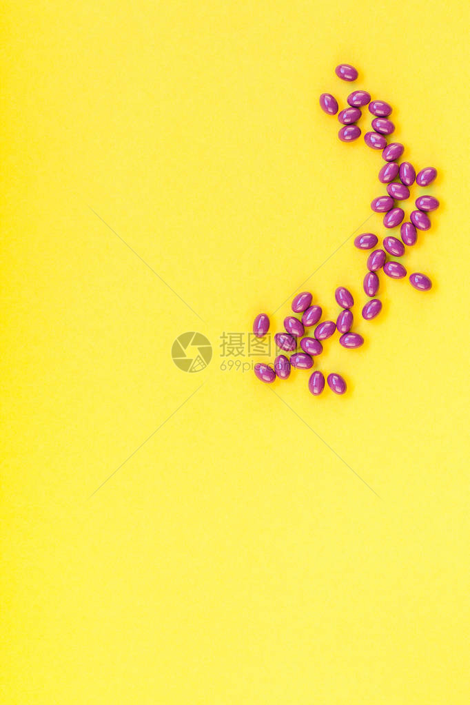 营养补充剂紫色药丸隔离在大胆的黄色背景与复制空间图片