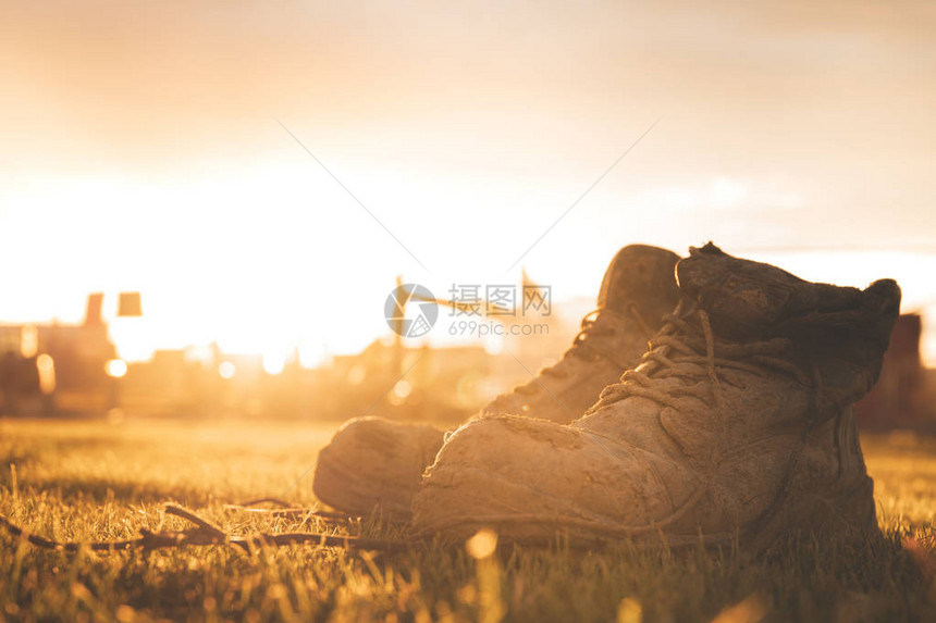在日落时与太阳一起拍摄鞋子被毁旧在图片