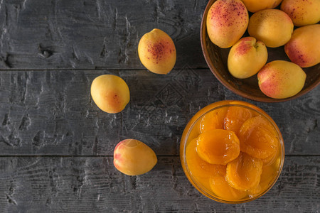 一碗杏仁和一碗果酱放在木制桌子上新鲜的自制果图片