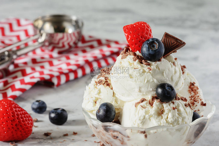 美味的冰冻甜点香草冰淇淋装饰着草莓蓝莓和巧克力薯片凉爽的夏日图片