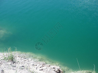 清澈的湖水和白色的岩石海岸的俯视图图片