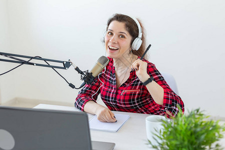 电台主持人概念作为电台主持人的女坐在工作室的白色背景图片