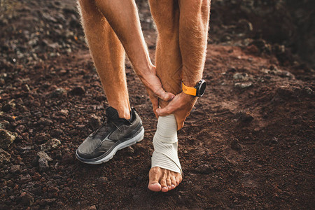 男跑步者抱着受伤的腿特写和痛苦腿伤在户外跑步时扭伤韧带或肌腱脚踝背景图片