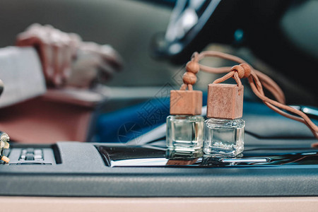 车内汽车面板上的汽车空气香水清新剂瓶小瓶子里的芳香液体模糊图片