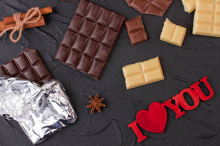 与巧克力棒的浪漫背景不同的巧克力片和题词我爱你图片