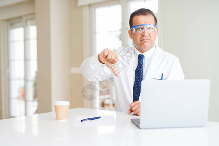 身戴专业眼镜的中年科学家男子使用笔记本电脑工作图片