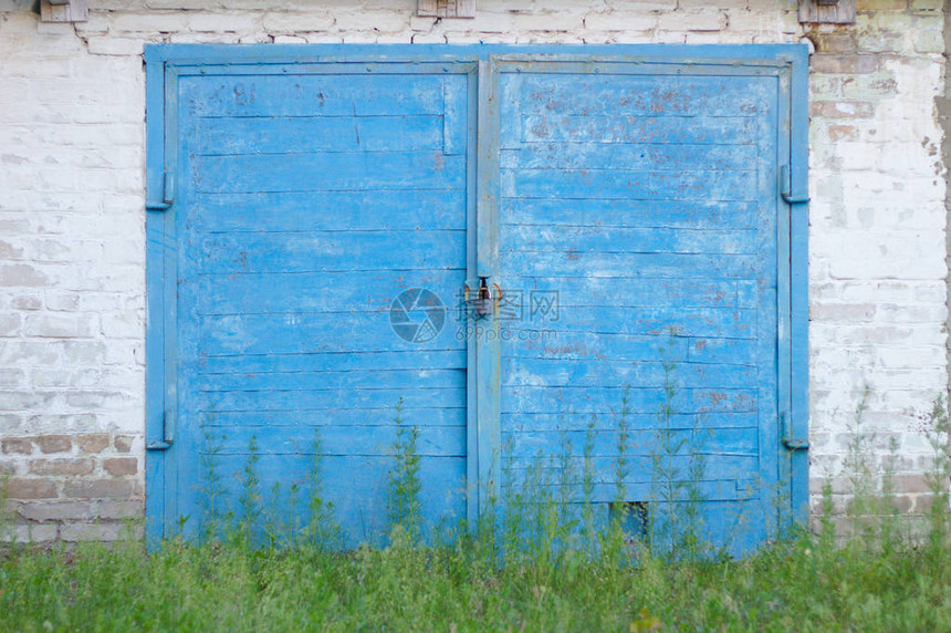 旧的蓝色木板门砖墙上挂着锁链图片