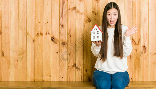 年青的亚洲女拥有一栋房子的纪念物庆图片