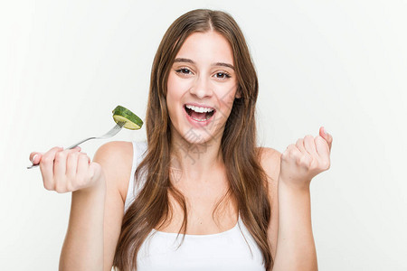 年轻的caucasian女人吃黄瓜图片