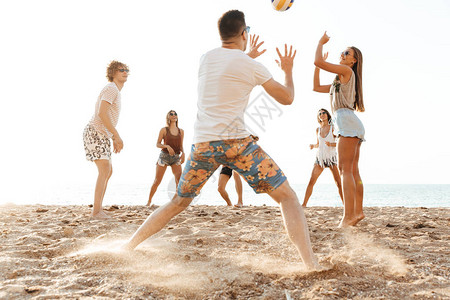 一群在海滩玩排球的快乐朋友们在图片