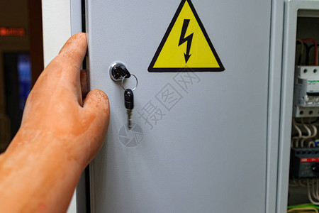 门上的标志轻地用电和手套电介质打开门在电网中戴图片