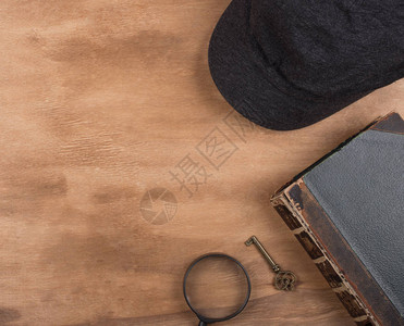 作为侦探或犯罪故事概念的侦探帽一本旧书一把钥匙和一个放大镜图片