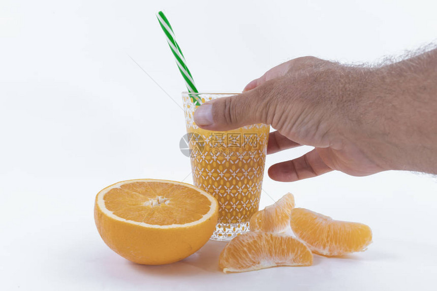 橙片半橘子和一只手将橙汁握在白色背景上图片