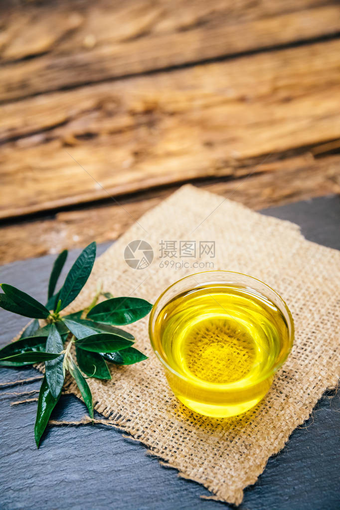 木桌上的有机天然和健康的冷压橄榄油健康素食或纯素食早餐碗中的初榨意大利或西班牙橄榄油图片