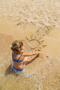 孩子在沙滩上画沙子图片