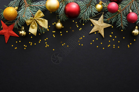 节日圣诞装饰品小玩意冷杉树枝深黑色背景上的五彩纸屑星图片