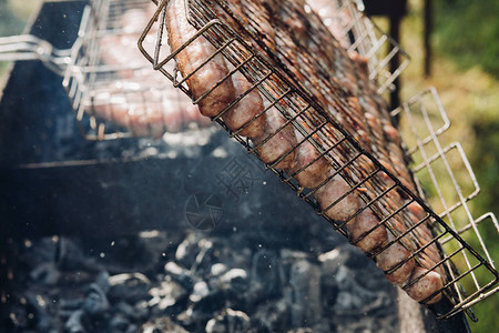 烧烤上美味鸡肉或猪肉香肠的特写镜头无法辨认的厨师在烤架上准图片