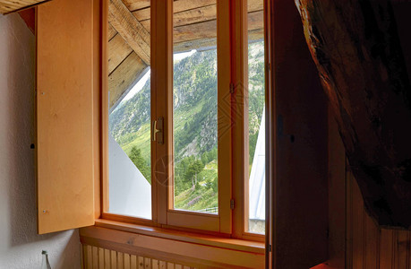 意大利皮埃蒙特阿尔卑斯山小木屋卧室的内景请注意木制覆层和日光进入图片