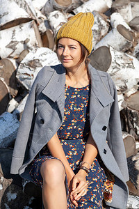 一个穿着针织帽外套漂亮裙子和靴子的开朗女人的肖像图片