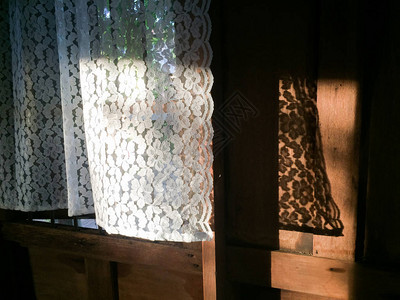 晨光窗户阴影和旧木背景中的美丽白色窗帘泰国房子温暖的语气图片