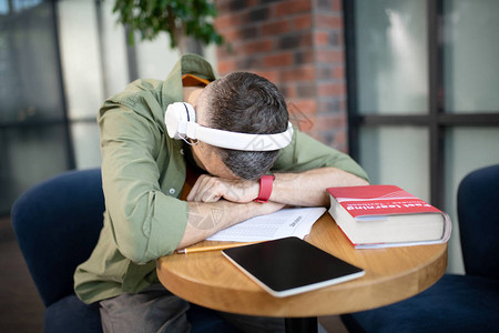 深色头发的疲倦学生在学习后戴着图片