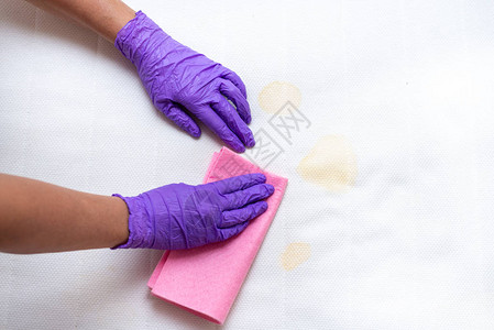妇女手用污渍清洁肮脏的床垫图片