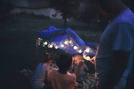 父亲带着孩子在后院的帐篷下玩耍图片