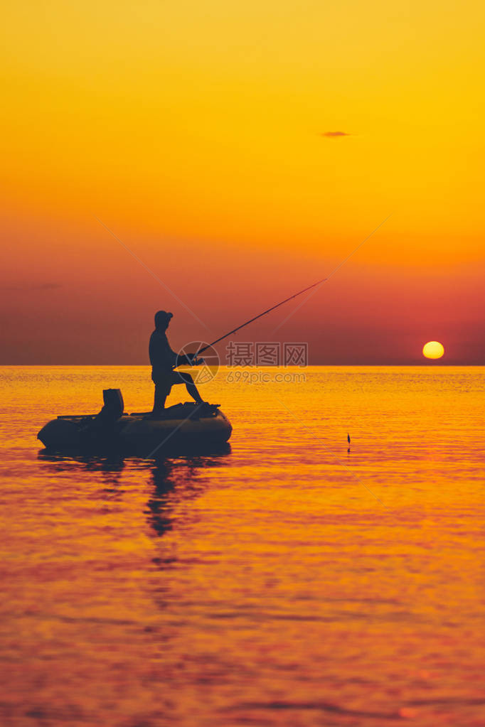 一只渔民在日落时在公海图片