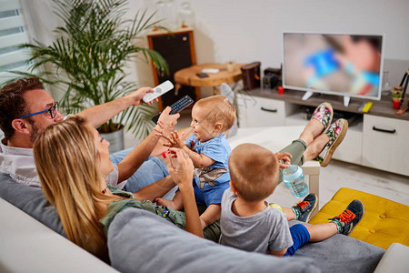 年轻的父母和男婴一起看电视图片