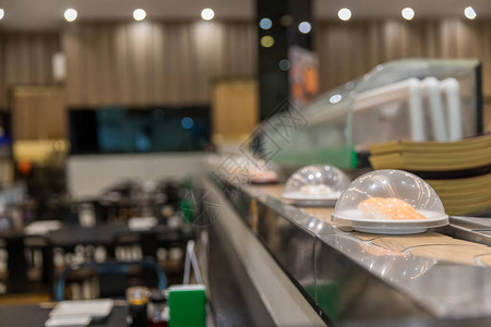 日本餐厅寿司传送带或式自助餐带寿司在背景模图片