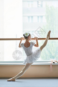 芭蕾舞女孩在芭蕾舞台上做练习芭蕾舞女演员在练习芭蕾舞时在巴里伸展熟练图片