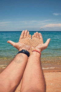 在热带沙滩上玩双手的人图片