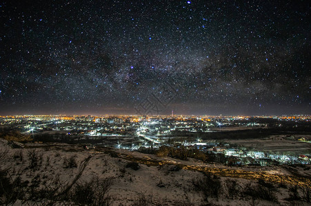 夜晚的城市在星空和银河背景的天际图片