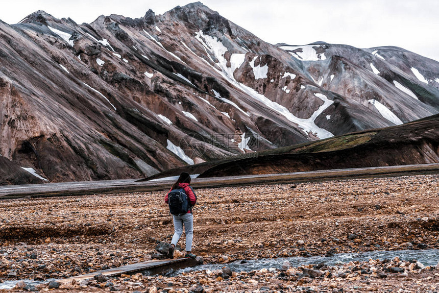 旅行者在冰岛北欧洲高地的Landmannalaugar超现实自然景观中远足美丽多彩的雪山地形以夏季徒步探险和户图片