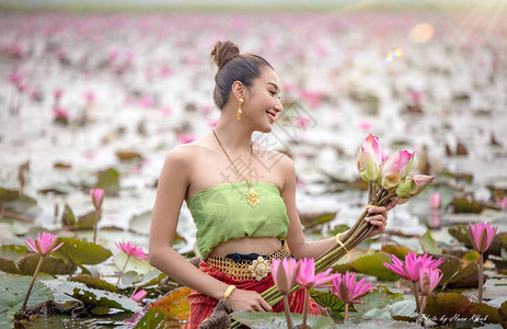 在泰国湖中握着粉红莲花的图片