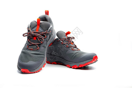 男子徒步鞋孤立在白色背景上灰红色登山鞋登山用的安全鞋冒险装备带安全鞋底的轻便橡胶徒步鞋现代背景图片