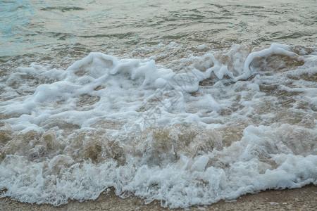 在暴风雨天气中拍打沙滩的海浪背景图片