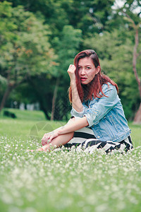 一个长发女人坐在草坪上图片