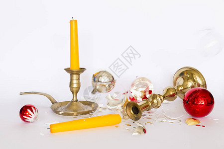 跌落和破碎的红色和银色圣诞小玩意和两个青铜烛台的正面图图片