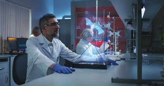 一名男科学家中镜头检查全息DNA链的背景图片