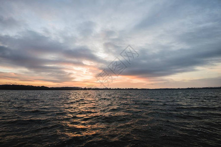 湖和森林的秋夕日落在阴云多图片