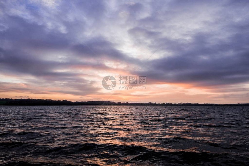 湖和森林的秋夕日落在阴云多图片