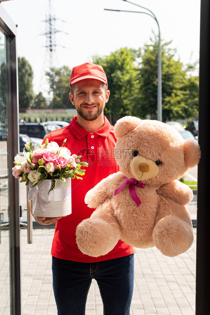 拿着泰迪熊和鲜花的正面送货员图片