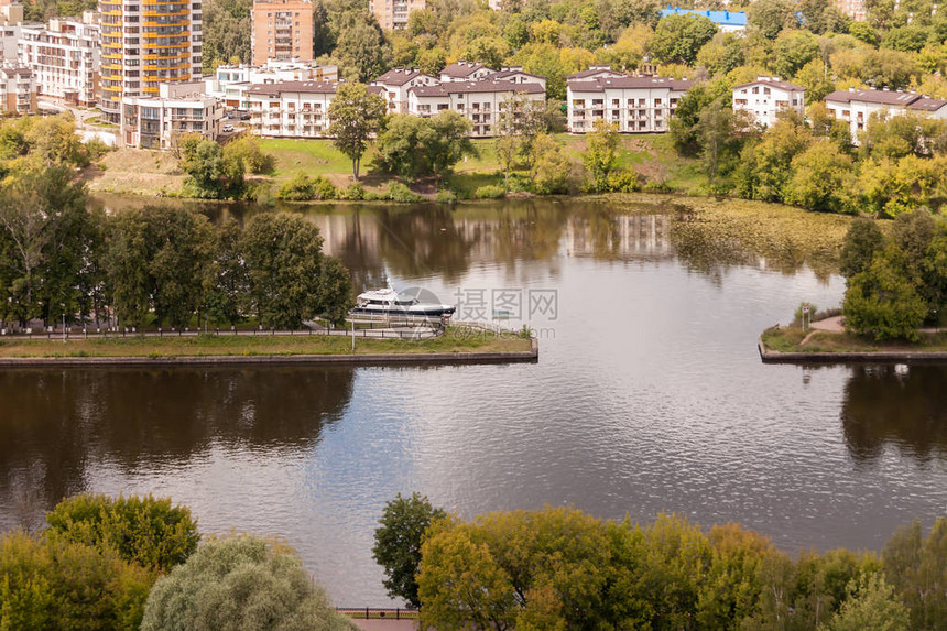 位于下层房子背景的住宅区外边有游艇在河上过秋天阳图片