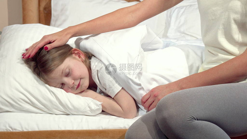 面目全非的女人为她熟睡的女儿盖好毯子图片