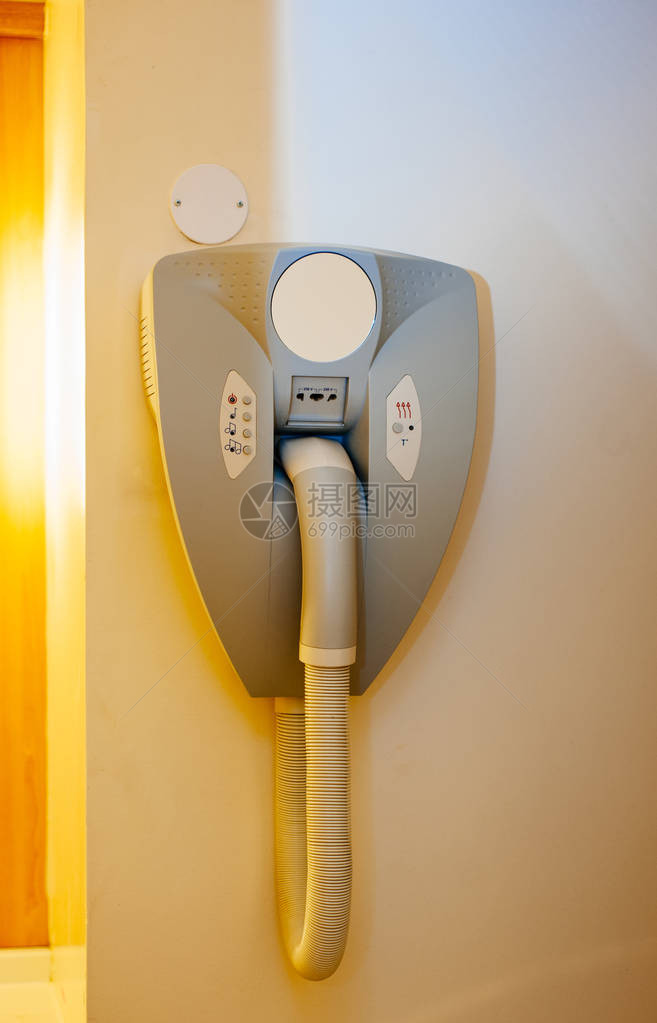 挂在现代旅馆浴室墙壁上并配有剃刀机电源插头图片