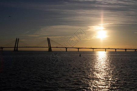 在海面日落美丽的背景下长的有线桥图片