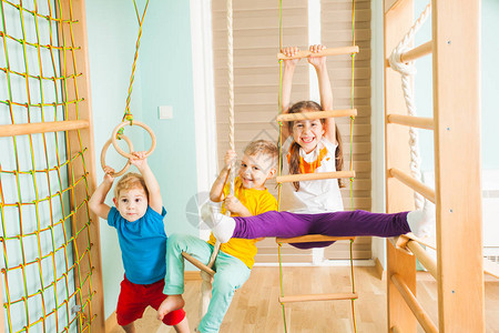 快乐微笑的兄弟姐妹在他们房间里的木制运动场玩耍图片