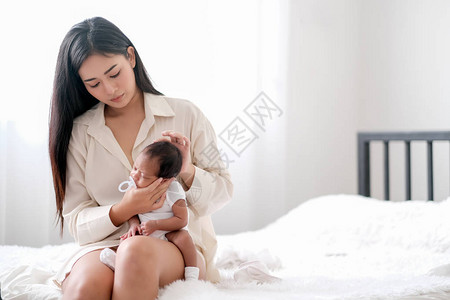 白衬衫亚洲母亲照顾她刚出生的婴儿图片