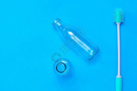 瓶式洗刷梳子和蓝底的空瓶子图片